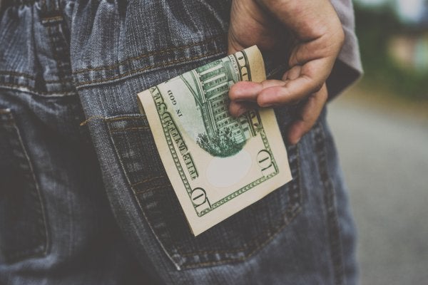 man putting money in pocket